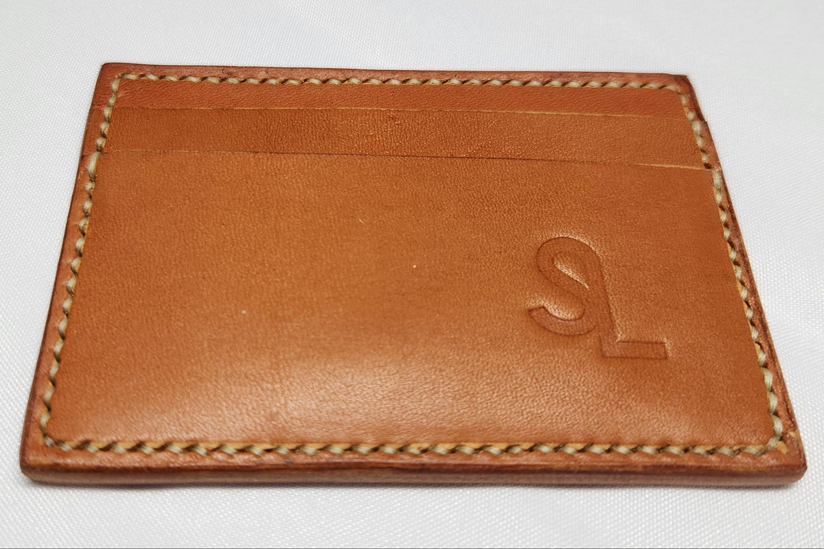 Brown leather cardholder with stitching detail on a white background